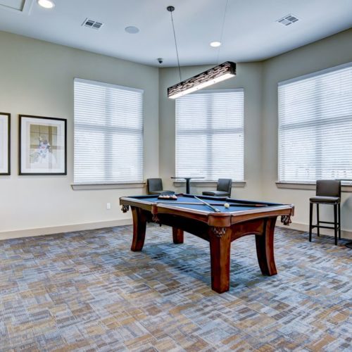 Clubhouse game area with pool table and TV