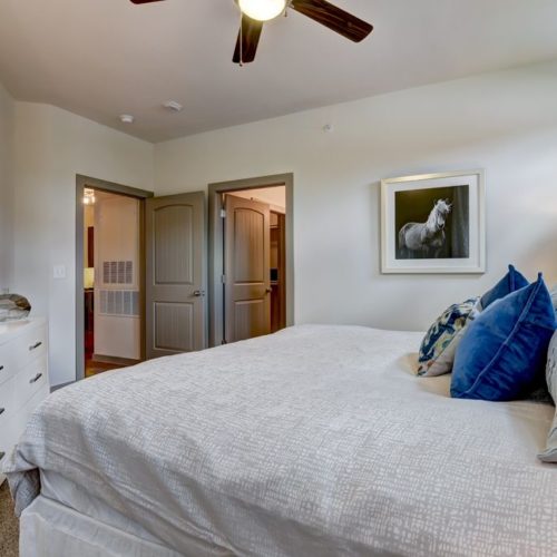 Alternate view of model bedroom with doors to living area and bathroom/closet