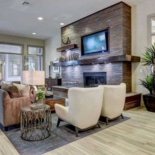 TV lounge area of clubhouse with couches around fireplace